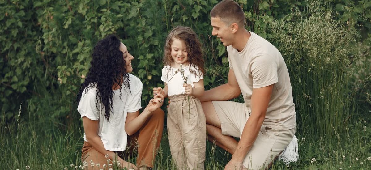 A joyful family enjoying time together in a lush green field.