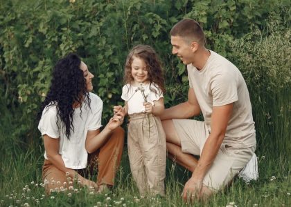 A joyful family enjoying time together in a lush green field.